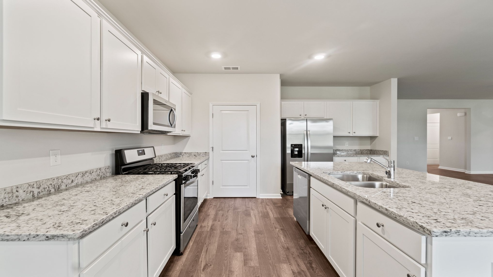 Riverview Landing open kitchen with center island, dining area, tile backsplash, and ample cabinet and pantry space