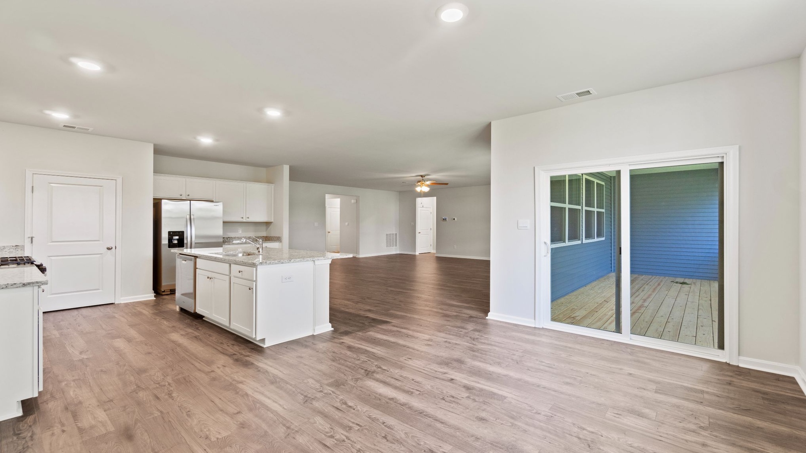 Open concept layout with sightline from living area to pantry, island kitchen, and staircase at Riverview Landing
