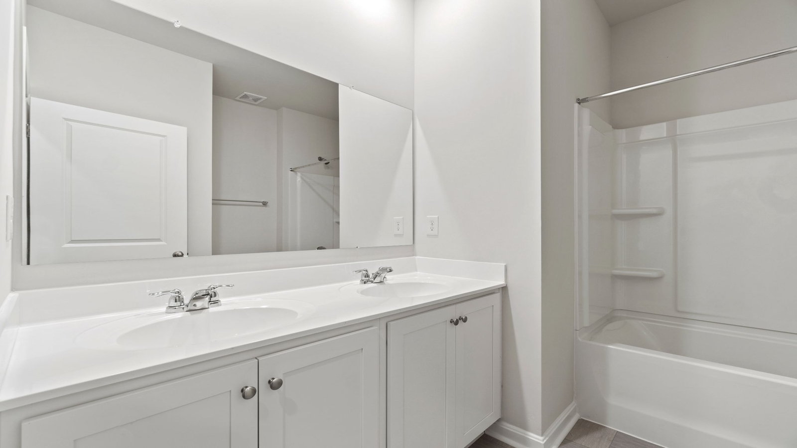 Sleek family-guest bath with single sink, mirror, and privacy-enhanced window above shower-tub at Riverview Landing