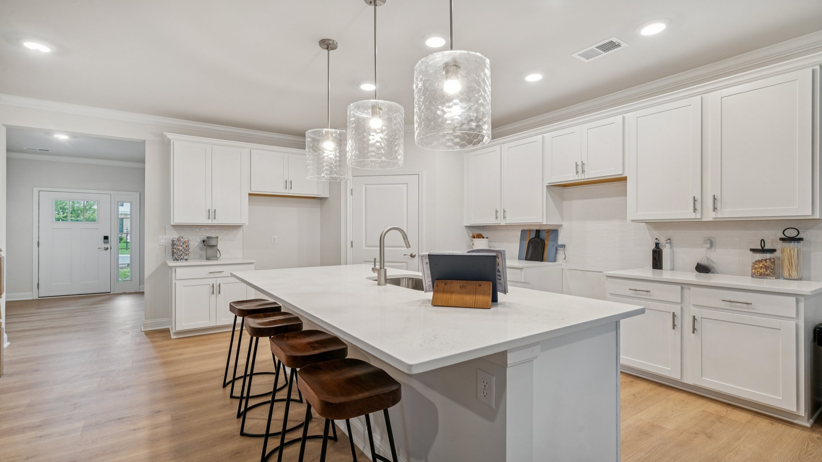 Central kitchen island with dining crafted to anchor the home with pantry, meal prep zones, guest and everyday gathering