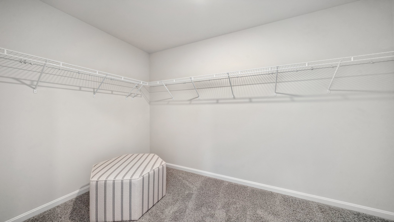 Primary bedroom walk-in closet enjoys ample space for clothes and accessories in Riverview Landing