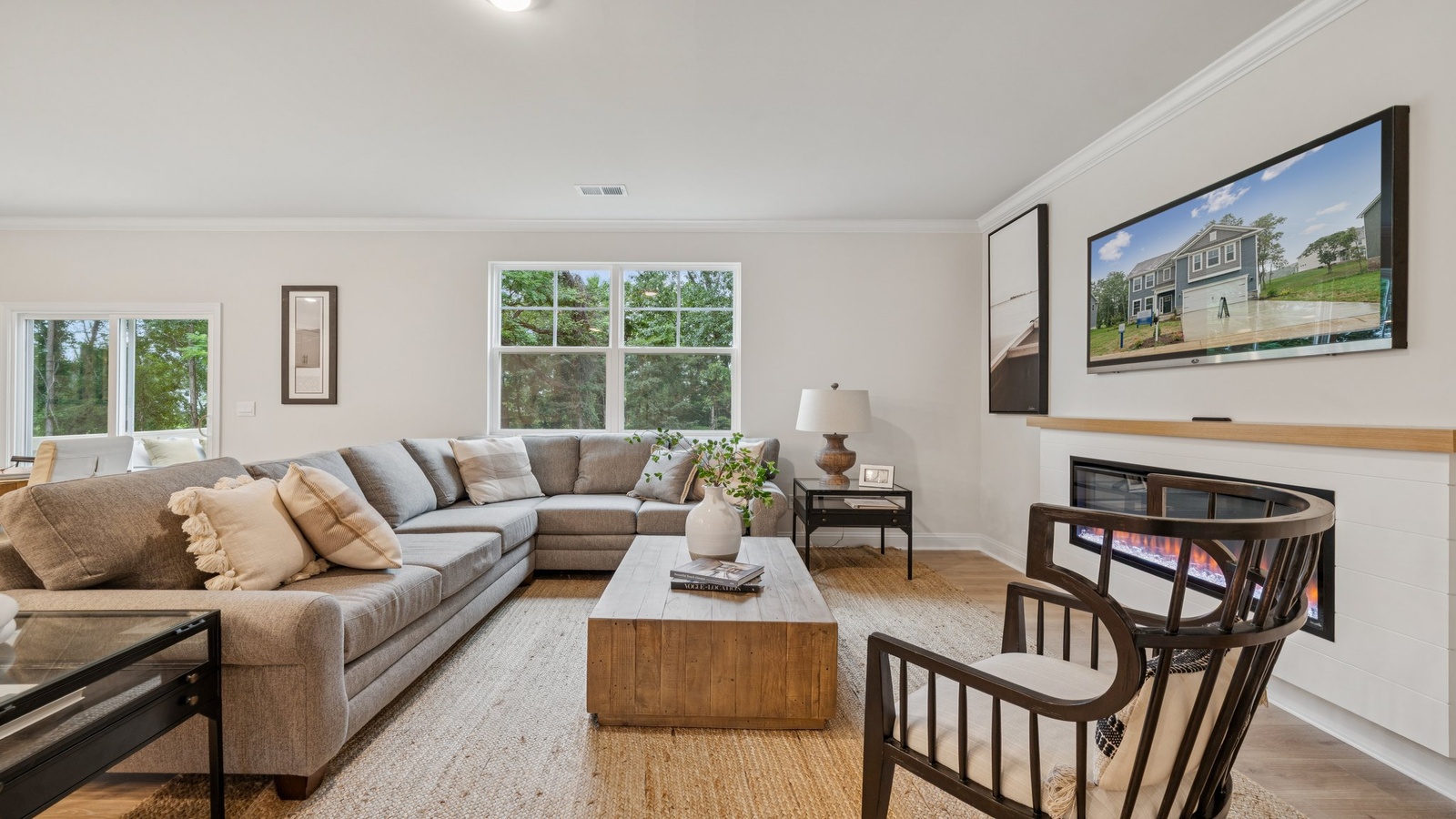 Living room in this New Construction Home features quality flooring, recessed lighting, and a Fresh Open Concept flow to the kitchen
