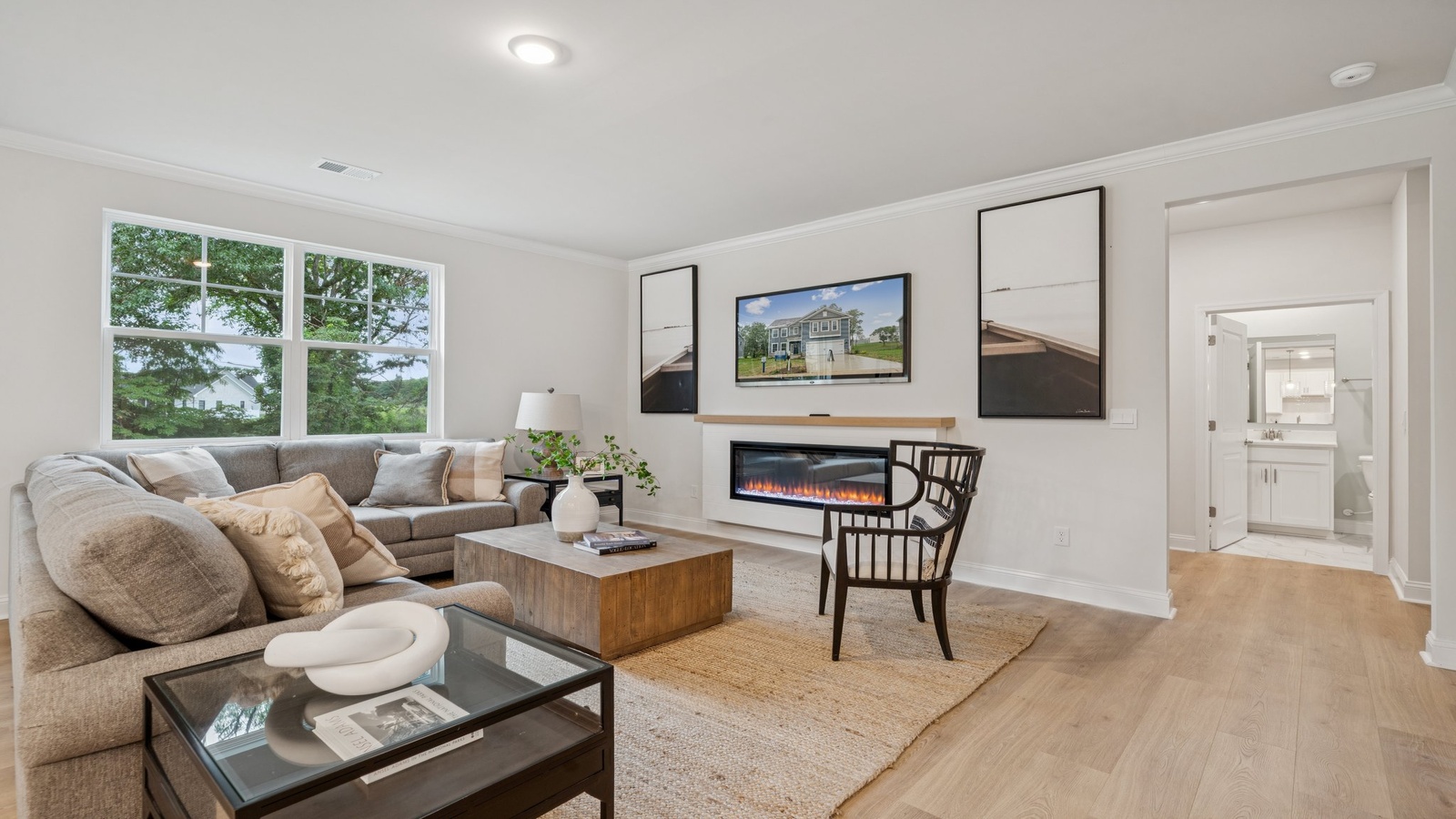 Spacious living room with large windows with natural light, open to the dining and kitchen areas in this New Build Home