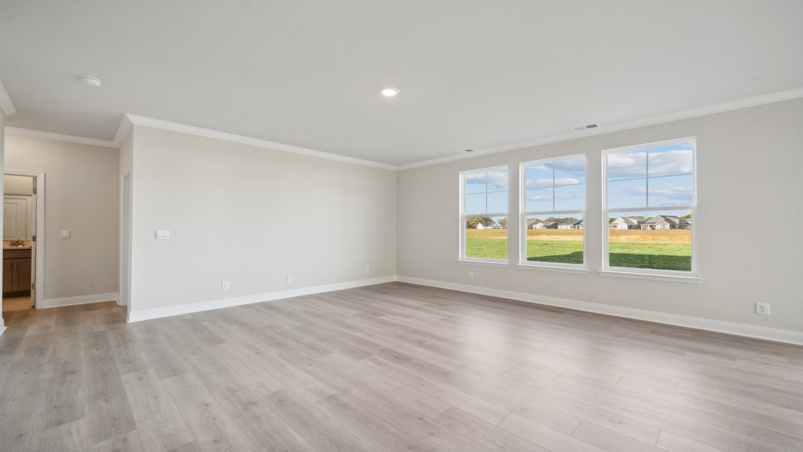 Living room, kitchen, and dining area function as one cohesive main space at Riverview Landing by D.R. Horton