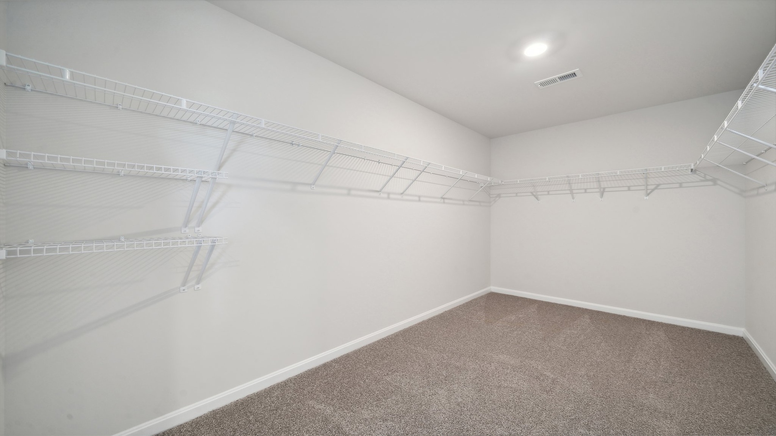 Primary bedroom walk-in closet enjoys ample space for clothes and accessories in Riverview Landing