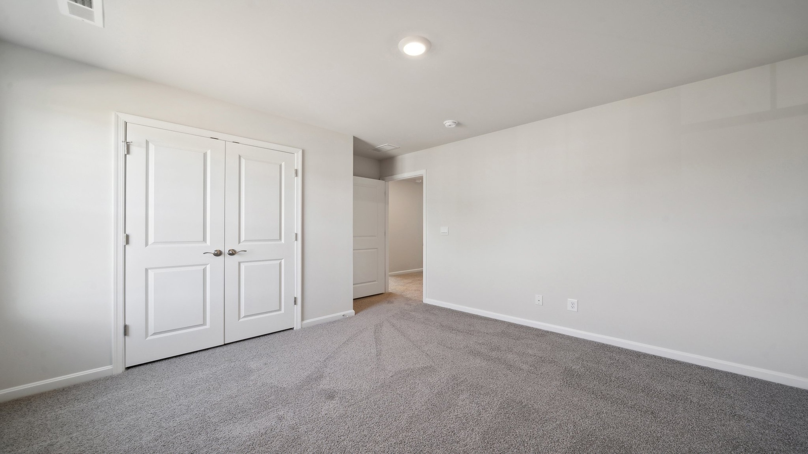 Owner’s suite offers natural window light, a spa-inspired en-suite bathroom, and a walk-in closet for everyday comfort