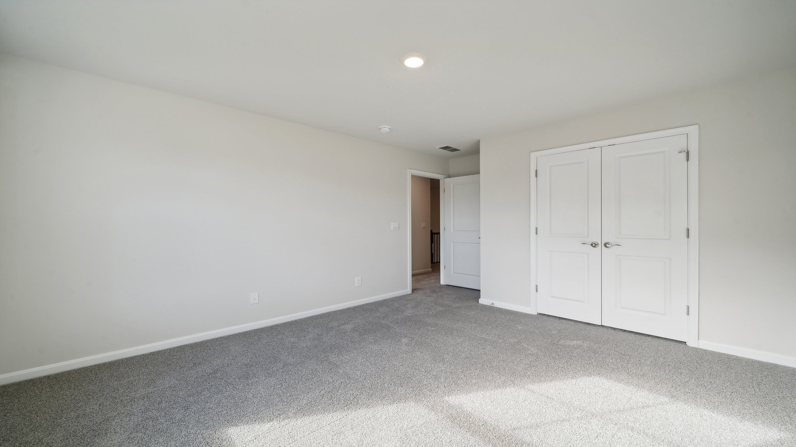 Owner’s suite offers natural window light, a spa-inspired en-suite bathroom, and a walk-in closet for everyday comfort