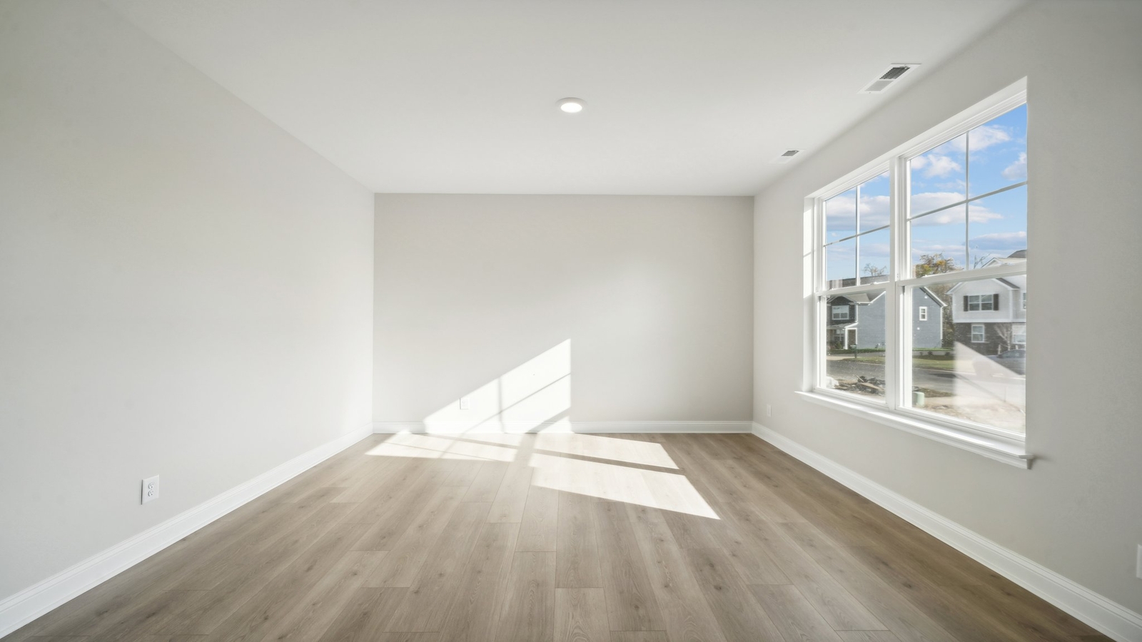 Modern front door, living room on right, quality flooring bright sunshine in Riverview Landing