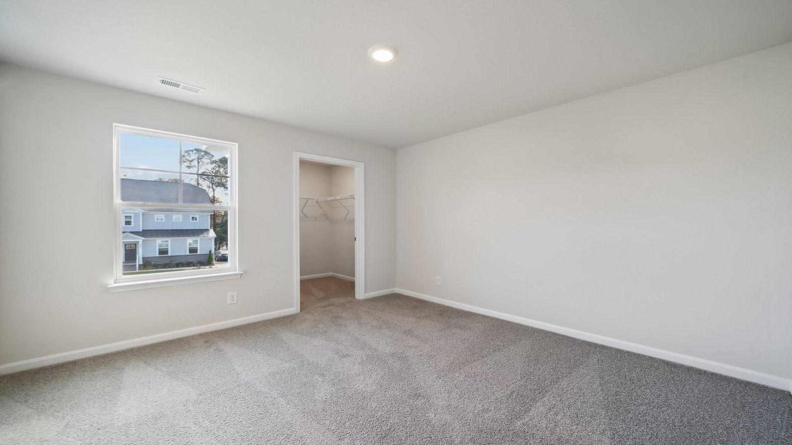 Spacious primary bedroom in our New Construction Home includes Modern Design finishes and quiet rear-facing windows.