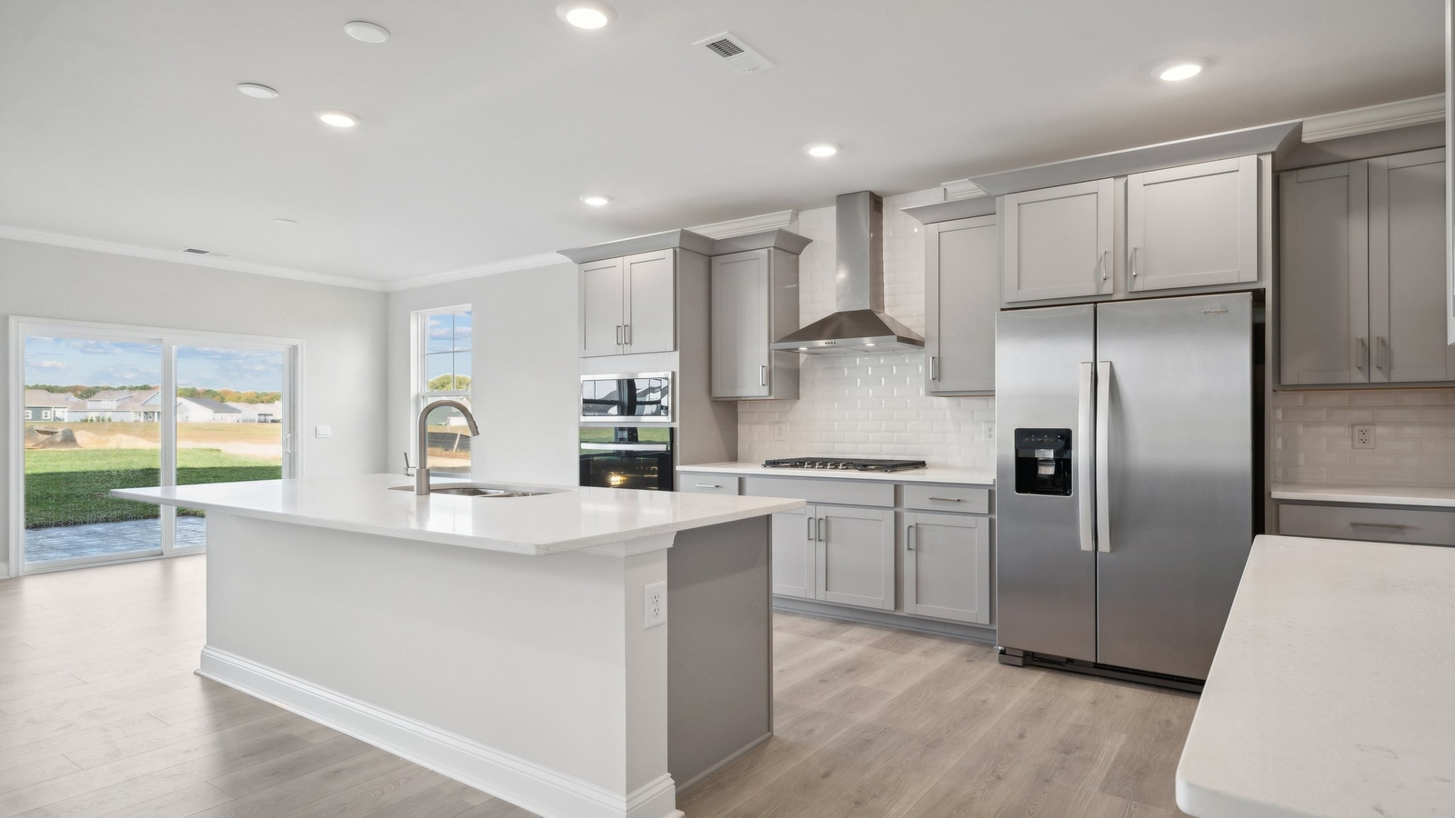 Modern kitchen with central island including seating, pantry, new appliances, stylish cabinetry in Riverview Landing