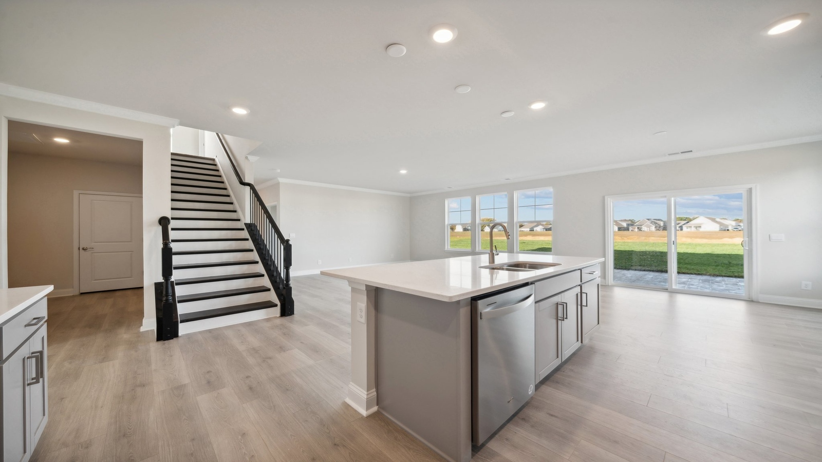 Kitchen island facing open-concept main living area with dining and family room access at Riverview Landing