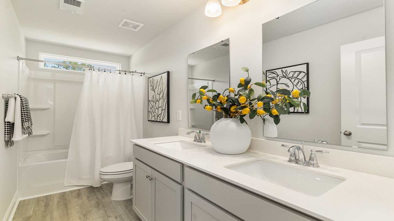 Riverview Landing secondary bathroom with bright white surfaces, single faucet, and built-in shower ledges