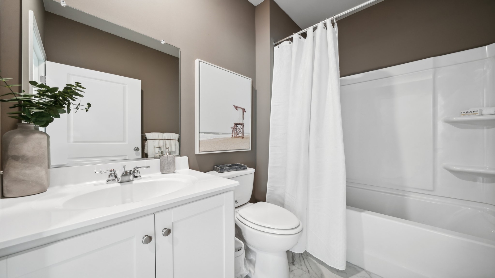 Family bathroom with tub-shower combo, vanity, mirror and bright lighting