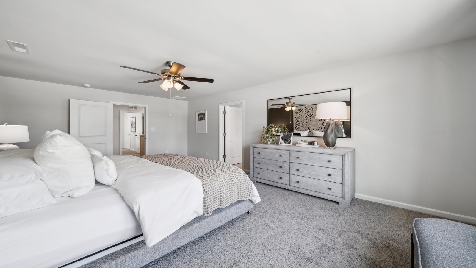 Primary bedroom designed for privacy and space with clean lines and a convenient flow into ensuite bathroom and walk-in closet