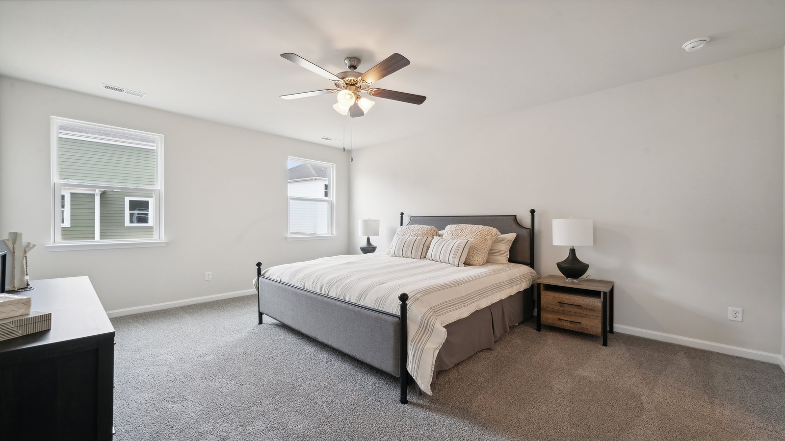 Primary bedroom in this New Home features ample space, double windows, quality carpet, walk-in closet, and a private ensuite bath