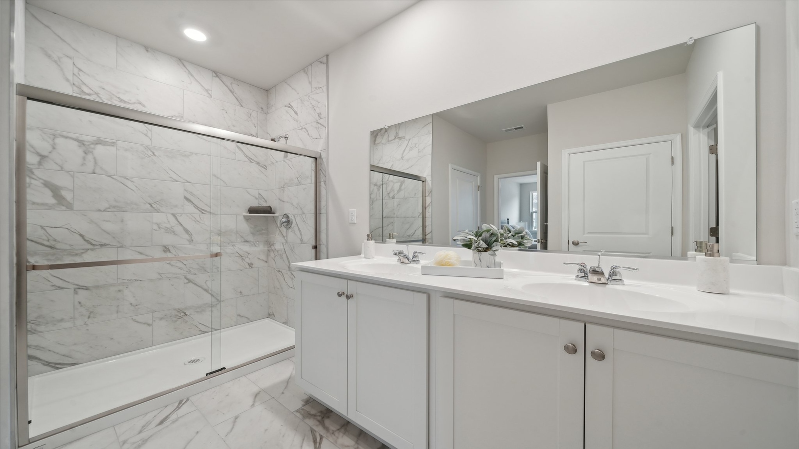 Primary ensuite bathroom in this D.R. Horton new home featuring dual sinks, expansive vanity, shower-tub, walk-in closet