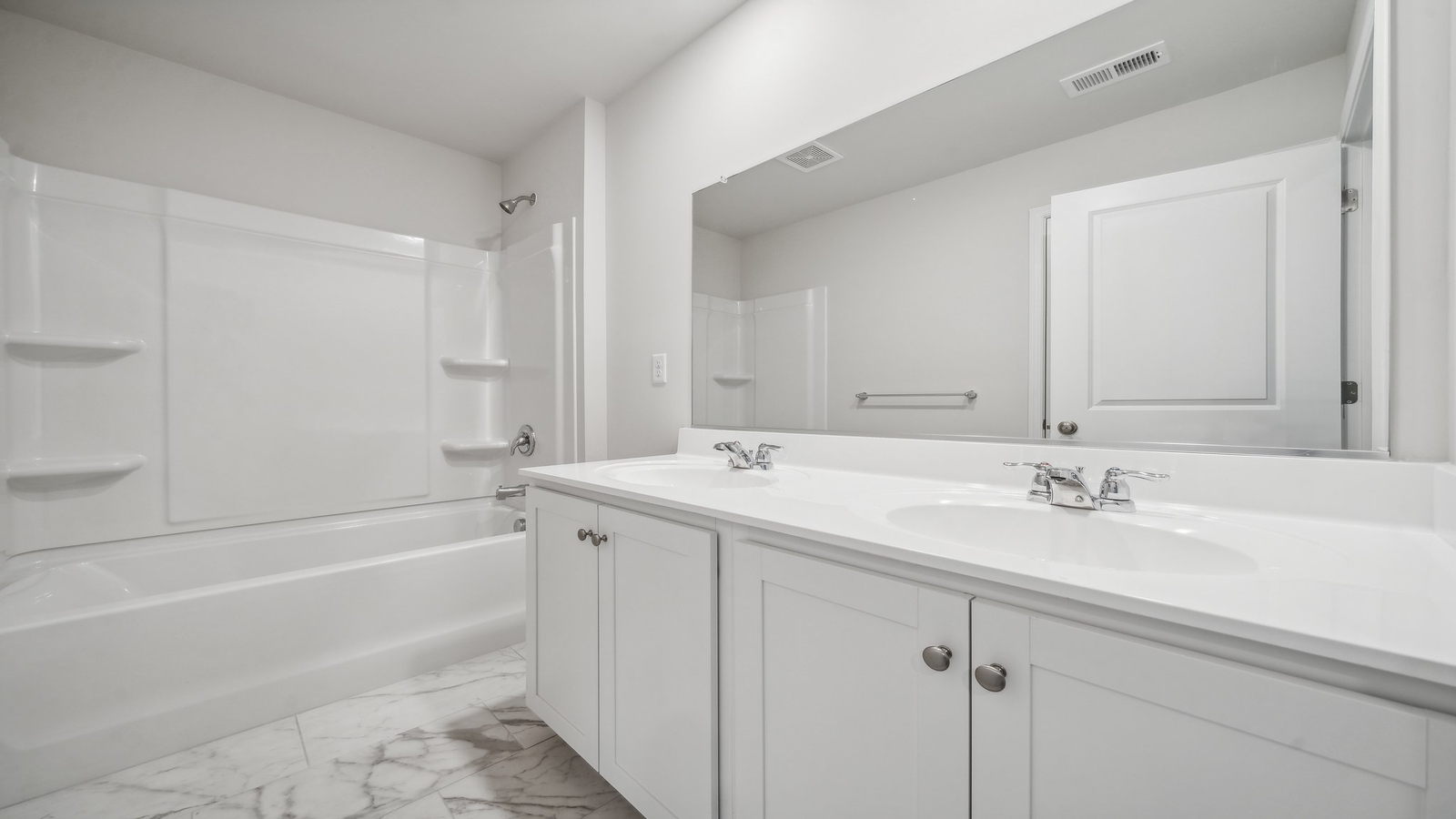 Family bathroom with tub-shower combo, vanity, mirror and bright lighting