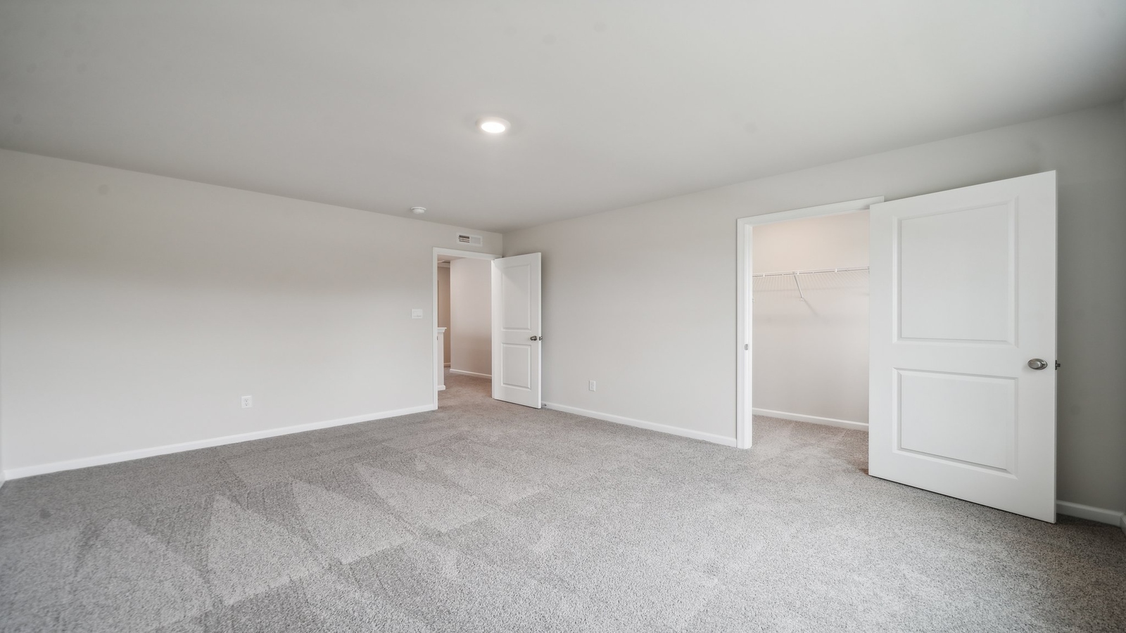 Bedroom with soft carpet, window view, and easy bathroom access