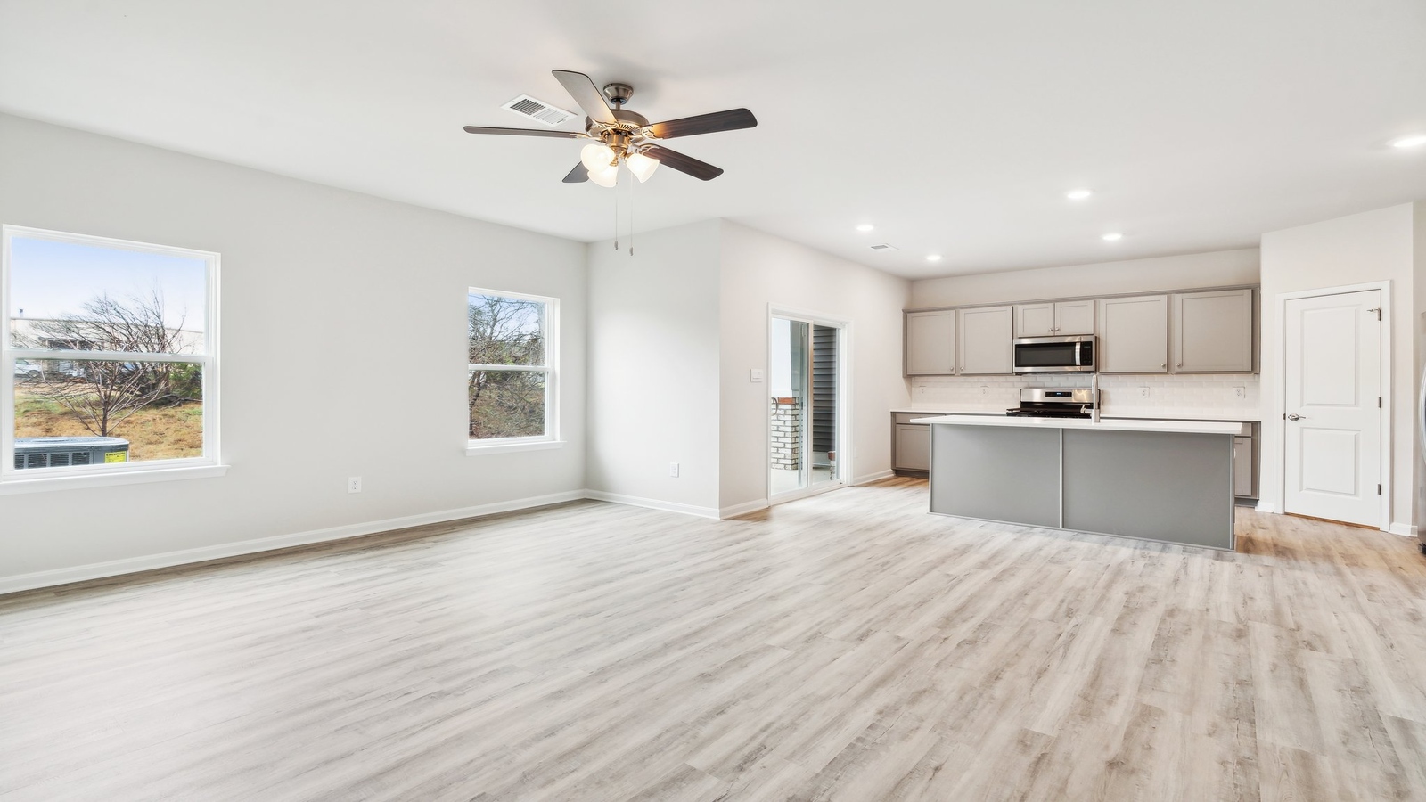 Functional layout with family room looking into modern kitchen and stairwell to upper bedrooms at Oak Crest Townhomes