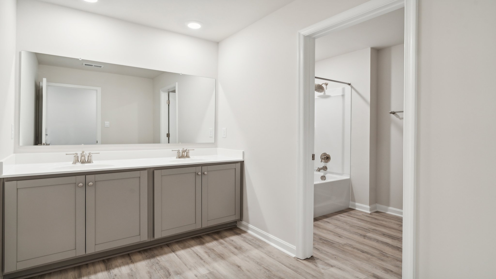 Secondary bathroom adds a quality combination shower-tub, cabinet storage, vanity, mirror at Oak Crest Townhomes