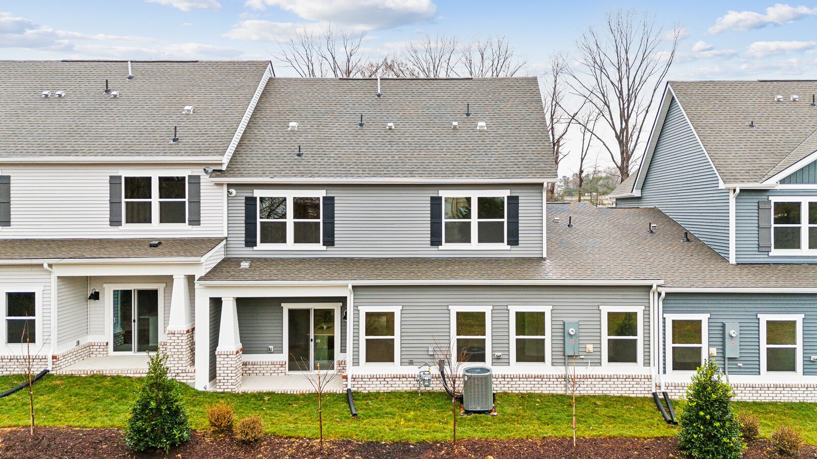 Backyard with concrete patio area offering room for seating, grill setup, and a transition from indoor to outdoor living