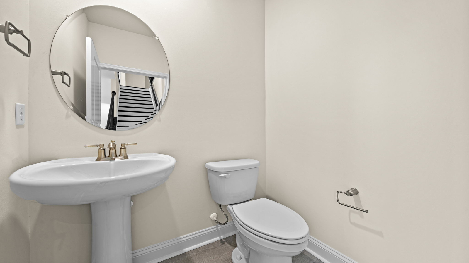 Half bath with white pedestal sink, single-lever faucet, and wall-mounted mirror in Maidens Farm