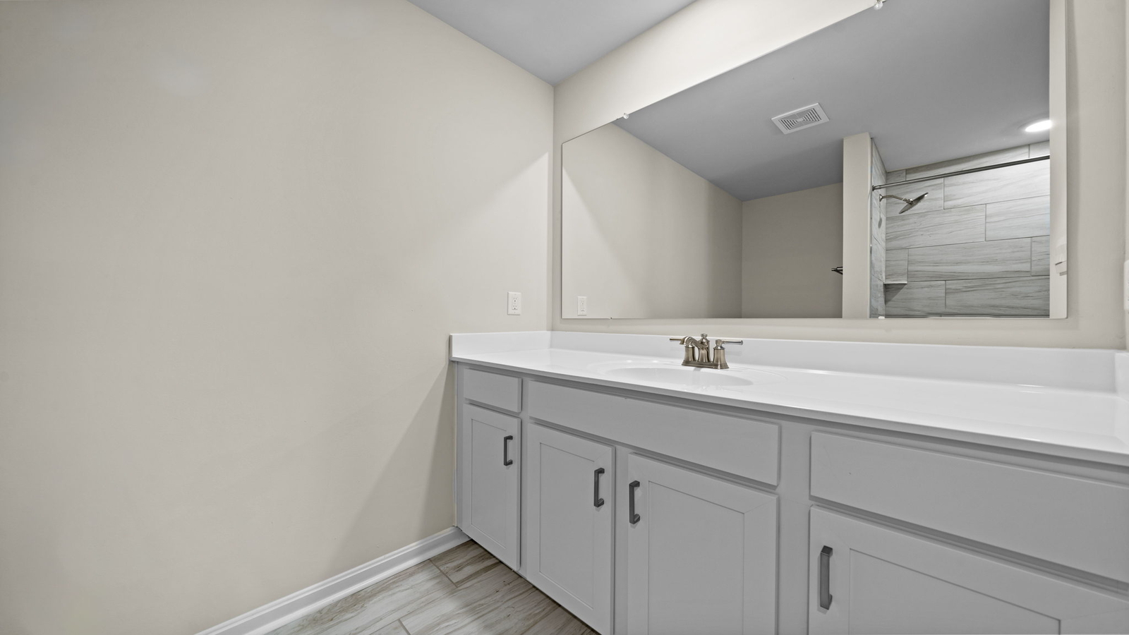 Secondary bath with built-in tub-shower combo, vanity lighting, and stylish finishes in Maidens Farm