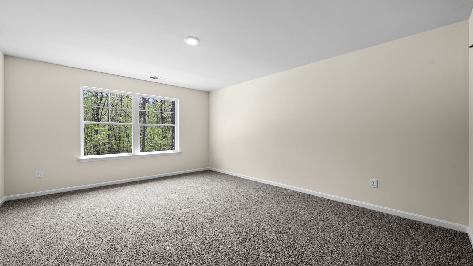 Secondary bedroom with window view, overhead lighting, and access to nearby bath and closet