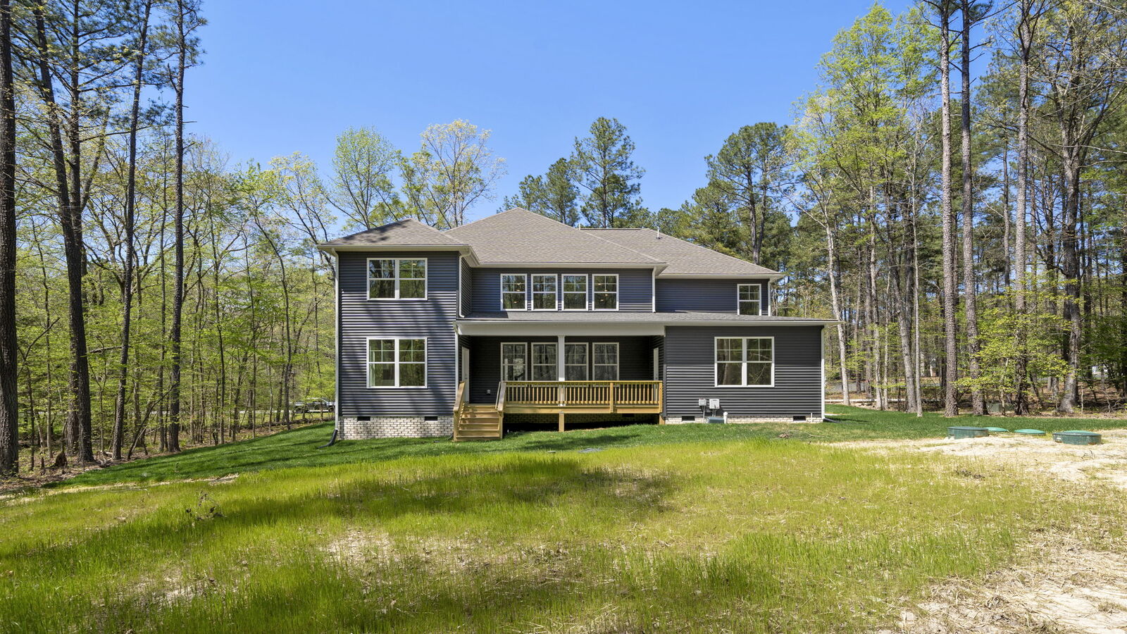 Rear covered deck-porch connected to dining - family room offering outdoor access in this New Construction Home
