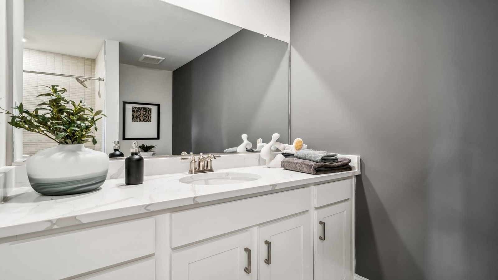 Family shower-bath, modern cabinetry, chrome faucet, storage options at Maidens Farm by D.R. Horton