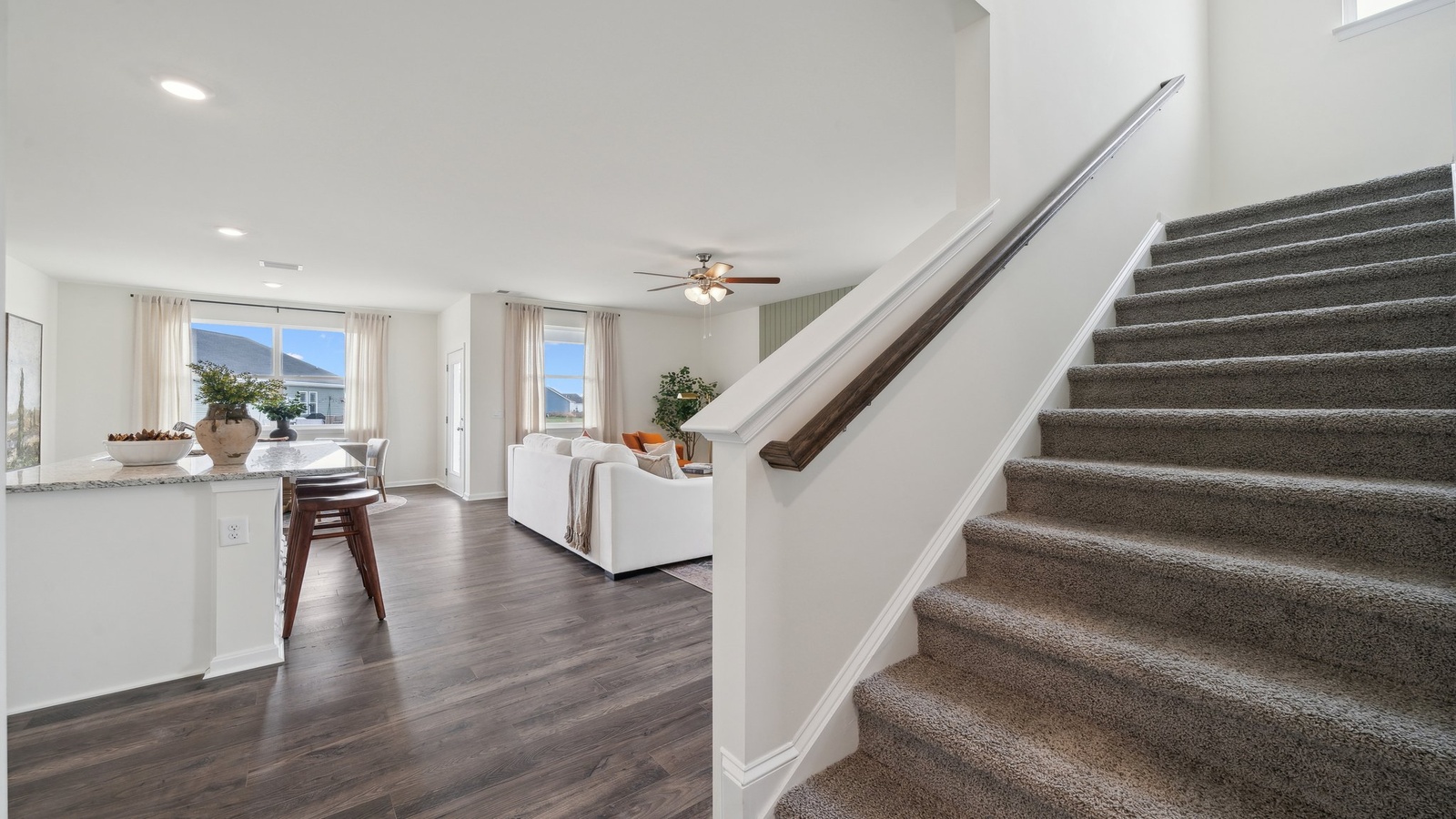 Spacious living room looking toward stairs, kitchen with island, dining, new appliances at Tooley Harbor