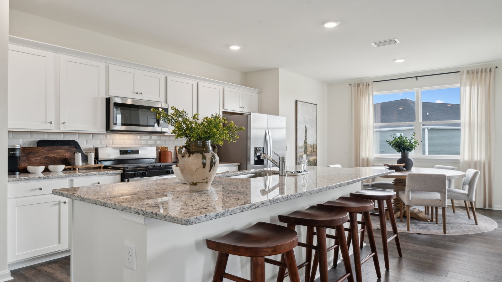 Kitchen, dining, family room blend together with ease of access to backyard view, upstairs access in D.R. Horton new home