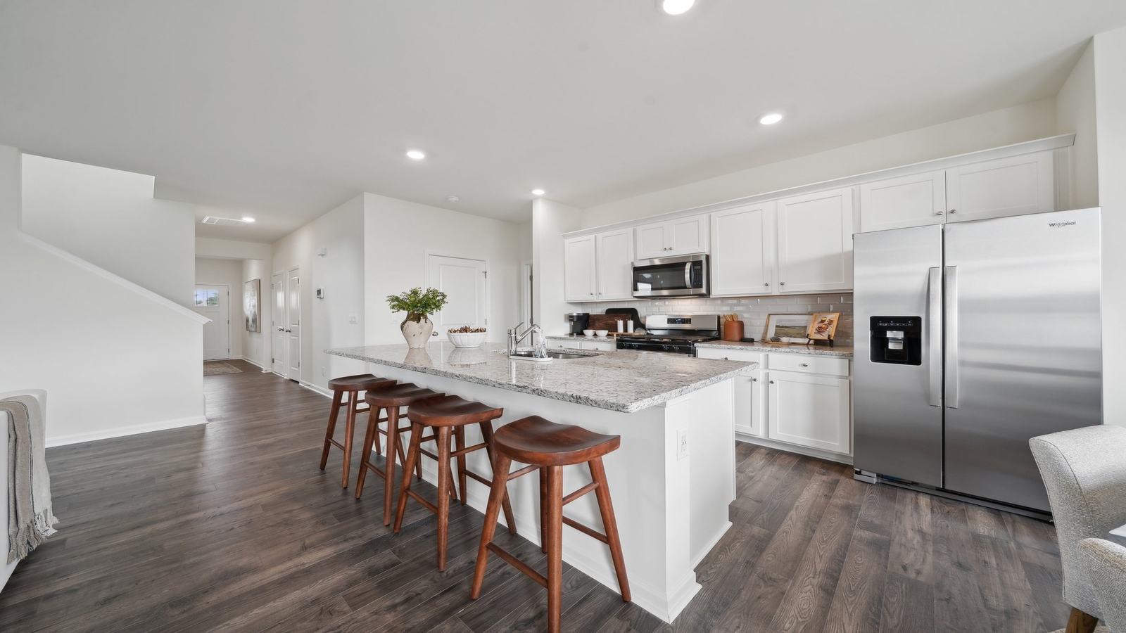 Spacious living room with view into dining and kitchen, staircase leading to the upper level in Tooley Harbor