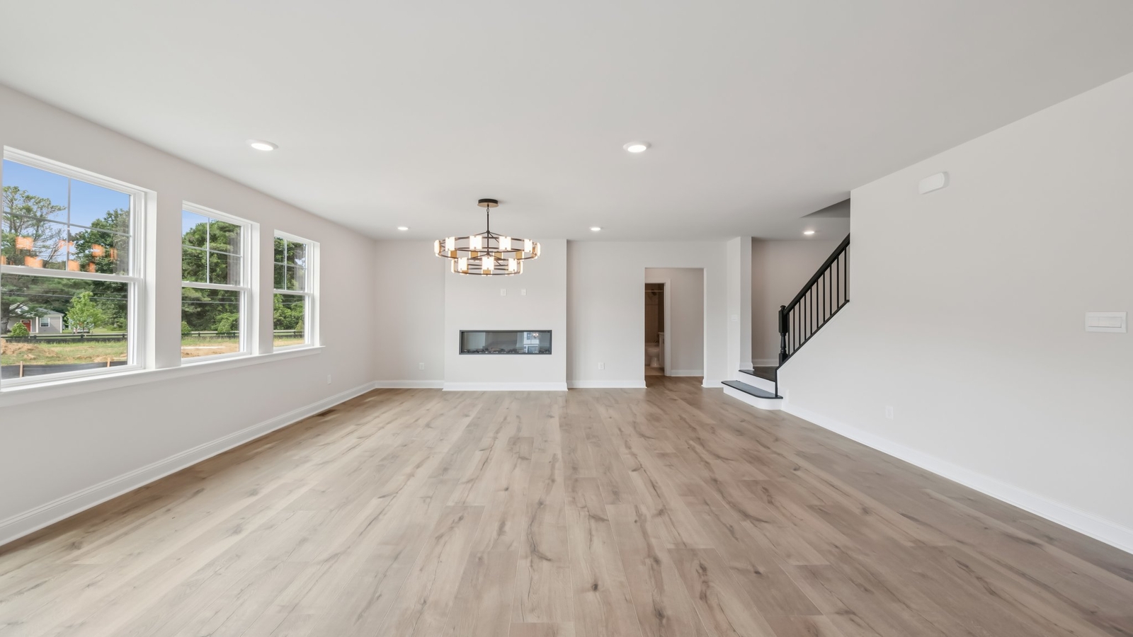 Great room with electric fireplace and a view of kitchen island and new appliance suite at Sheppard Mill