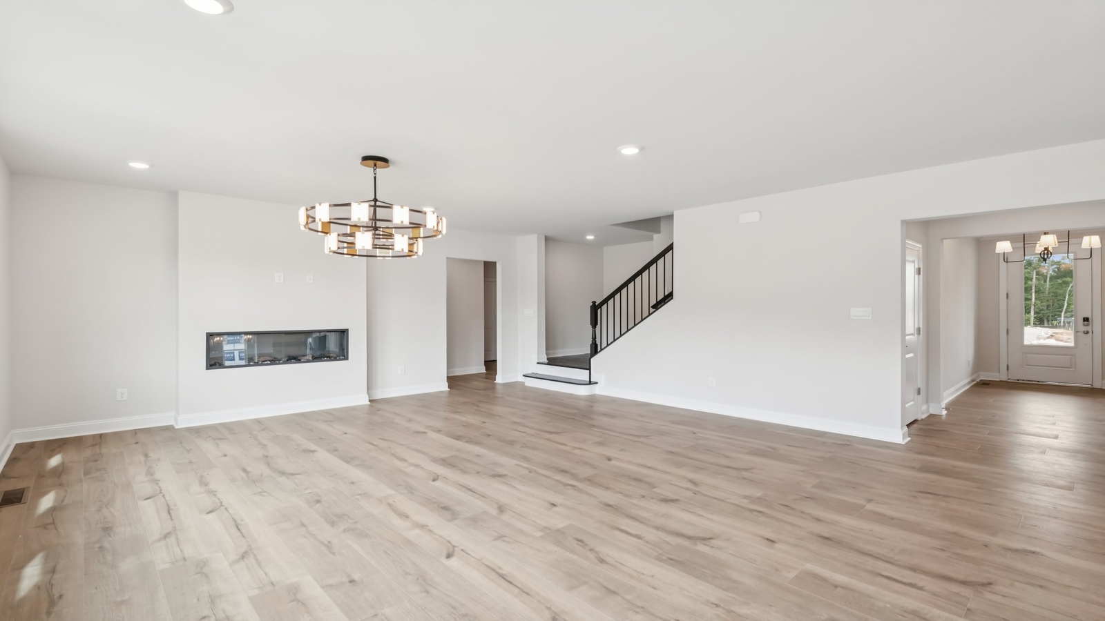 Living-Dining rooms with electric fireplace, natural light, and seamless flow into kitchen with surface island