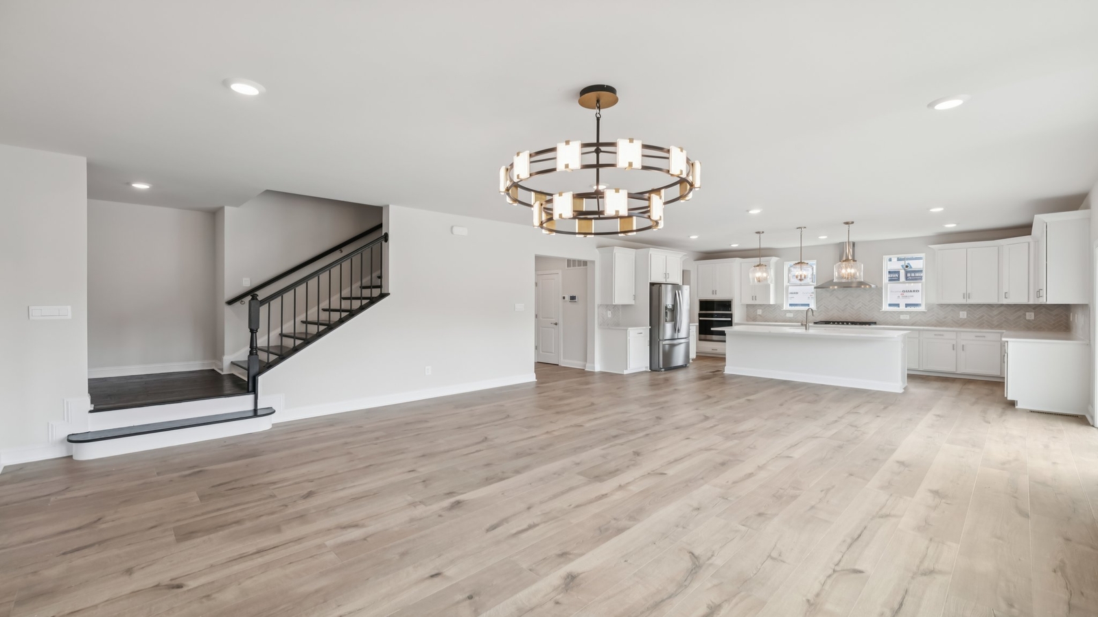 Open concept featuring living area with electric fireplace, dining-kitchen island in Sheppard Mill