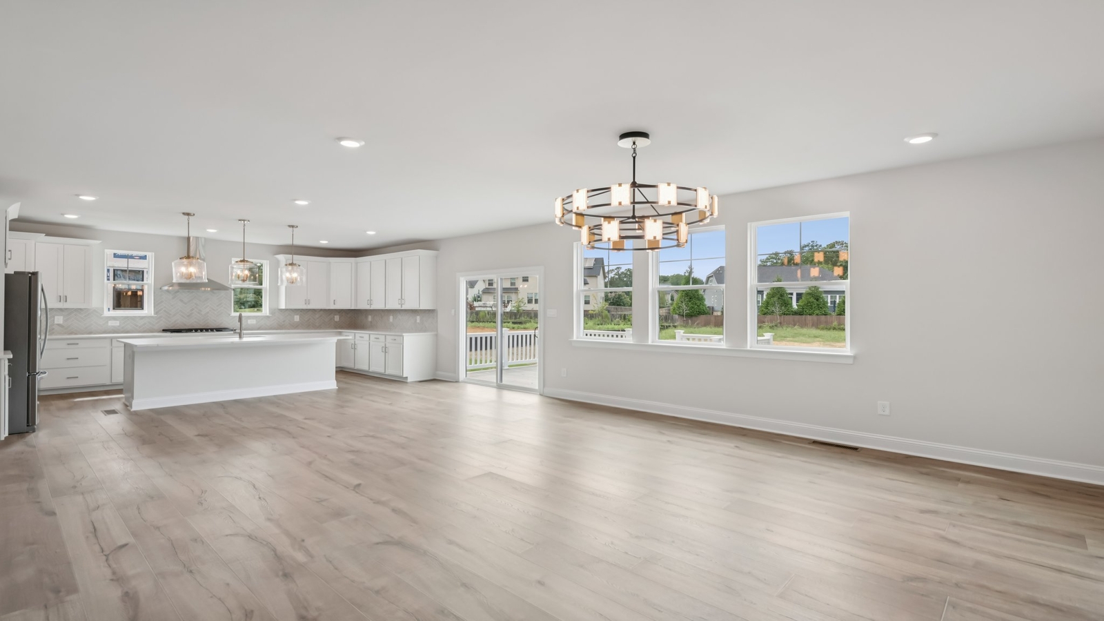 Living room, kitchen, and dining area function as one cohesive main space at Sheppard Mill by D.R. Horton