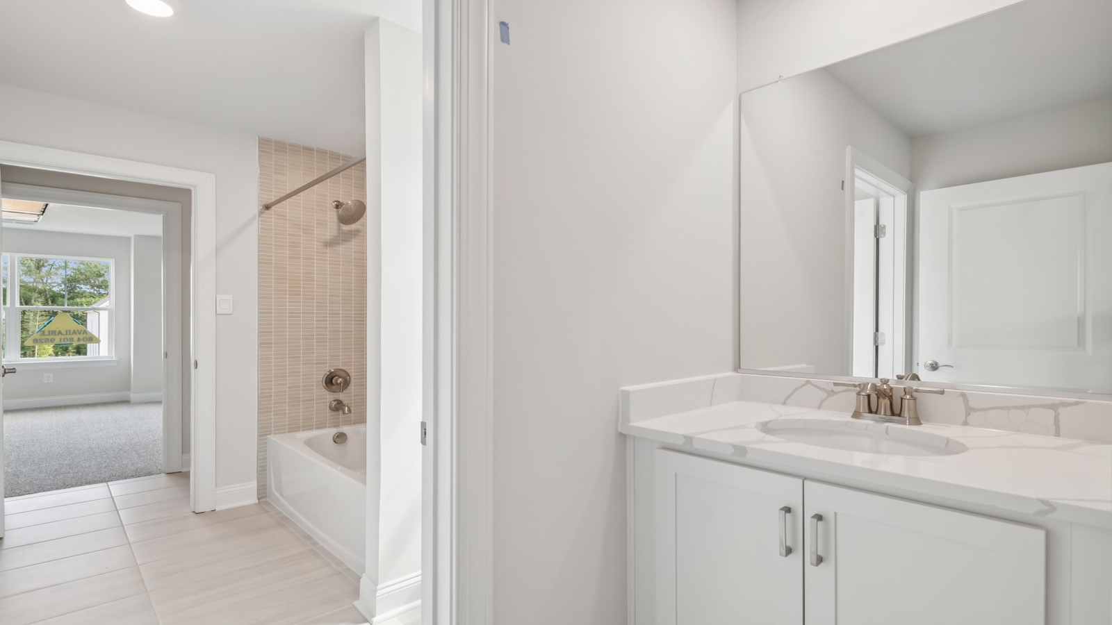 Full bathroom at Sheppard Mill with built-in tub and shower combo, vanity lighting, and framed mirror