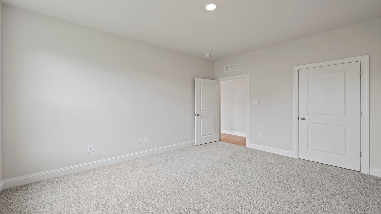 Spacious primary bedroom in our New Construction Home includes Modern Design finishes and quiet rear-facing windows.