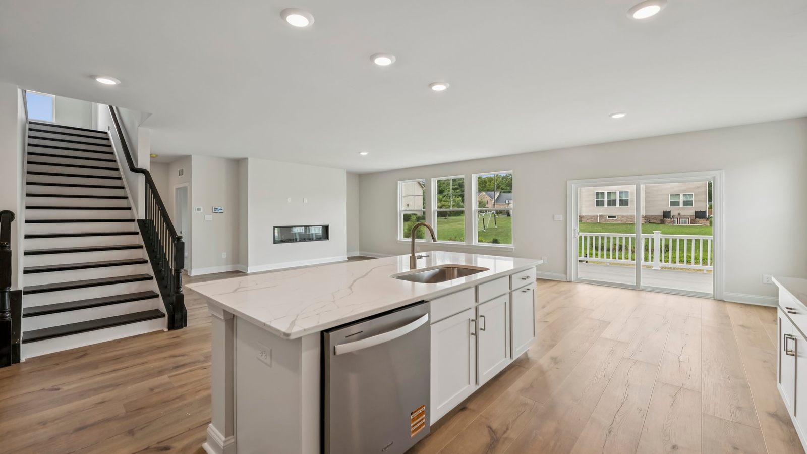 Open main living area with kitchen island, dining and family room designed for everyday function at Sheppard Mill