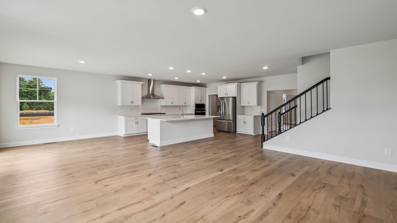 Kitchen island in this New Home includes seamless integration with dining-living areas and Open Concept floor plan
