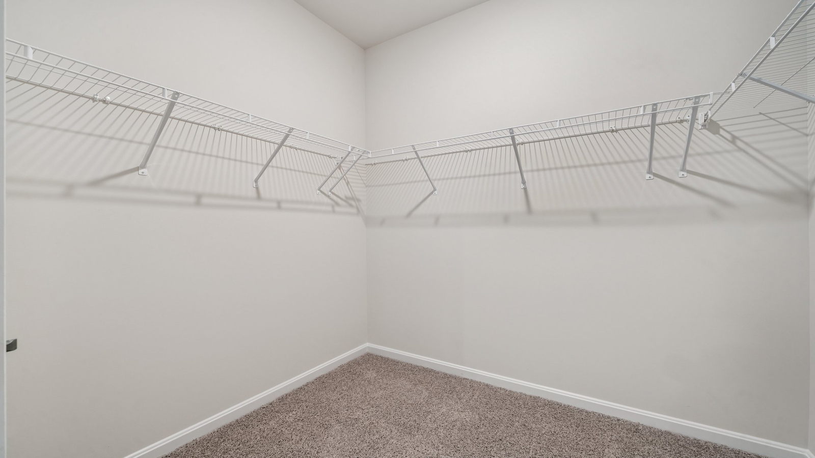 Primary suite walk-in closet in Smith Farm new home with built-in shelving and generous storage