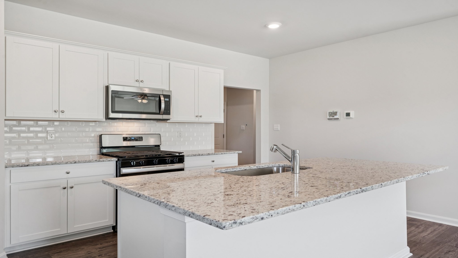 Sleek kitchen island with brand-new appliances and open view to accessed great room-dining room