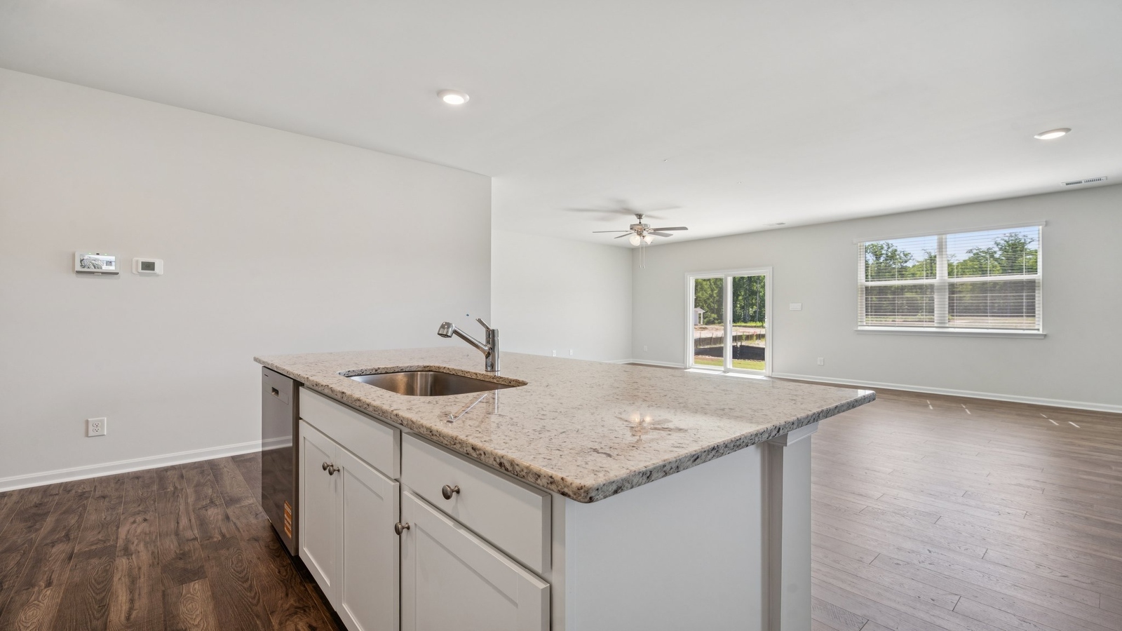 Kitchen island in this New Home includes seamless imagination with dining-living areas and open concept floor plan