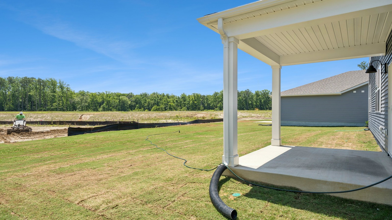 Covered rear patio in this D.R. Horton New Home with outdoor living and private backyard views from the Open Concept layout