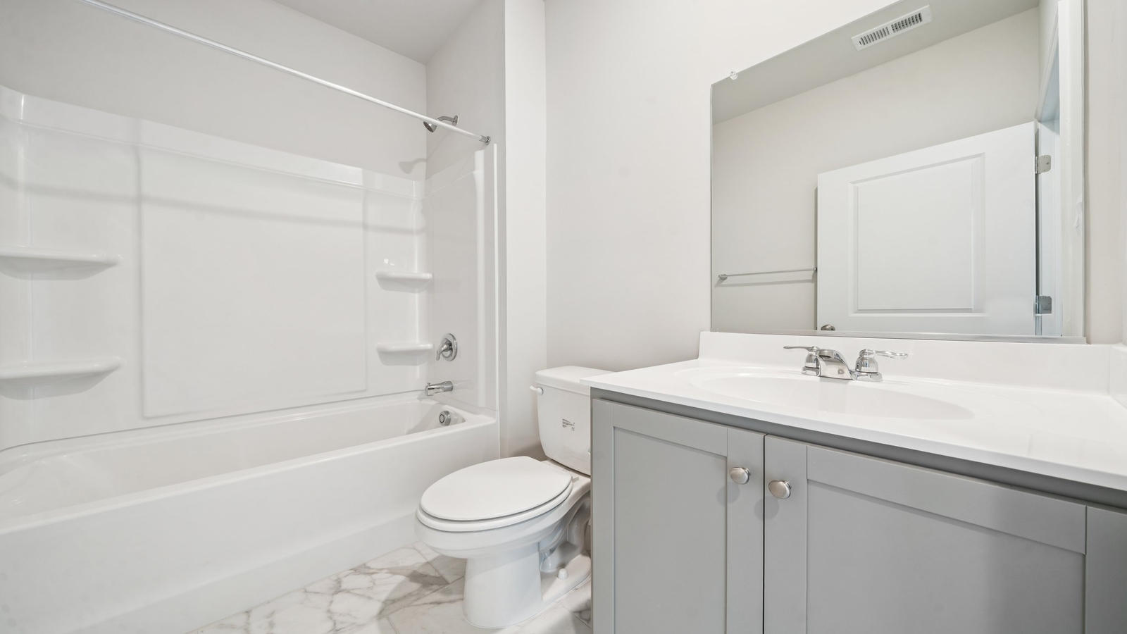 Secondary bath with built-in tub-shower combo, vanity lighting, and stylish finishes in Smith Farm