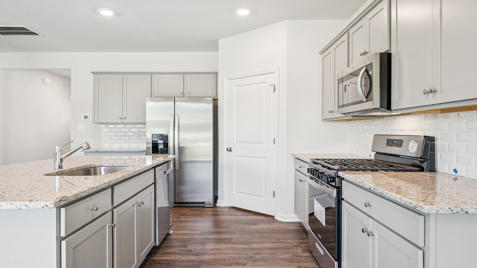 Central kitchen island with seating anchors our main level with meal prep zones, new appliance suite, dining-living areas