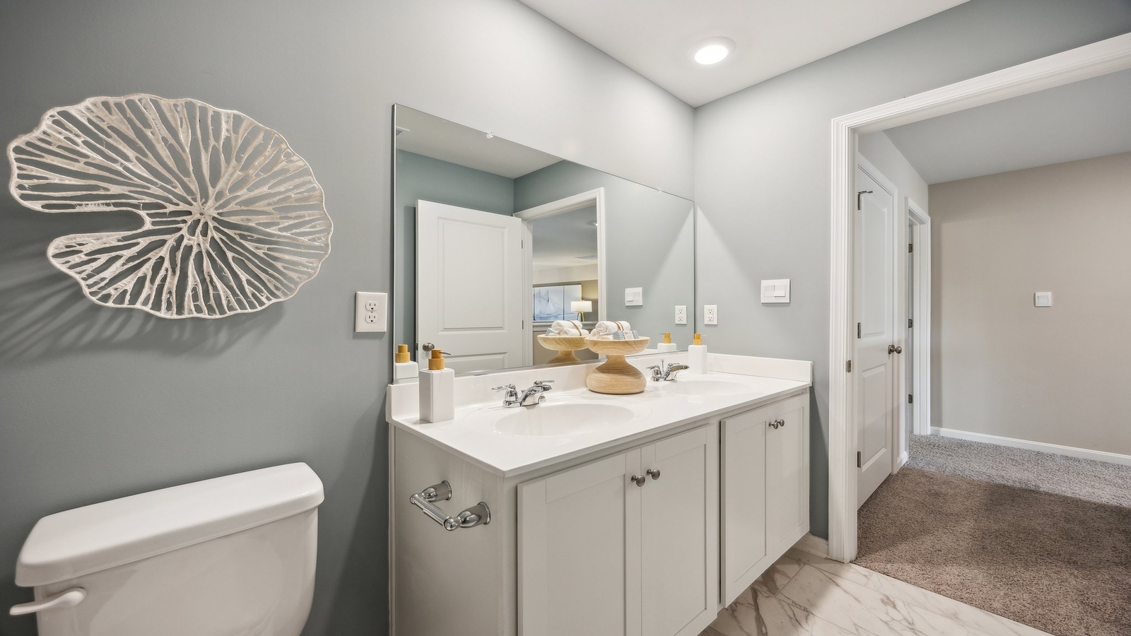 Half bathroom with chrome fixtures, pedestal sink, mirror, towel holder, white walls