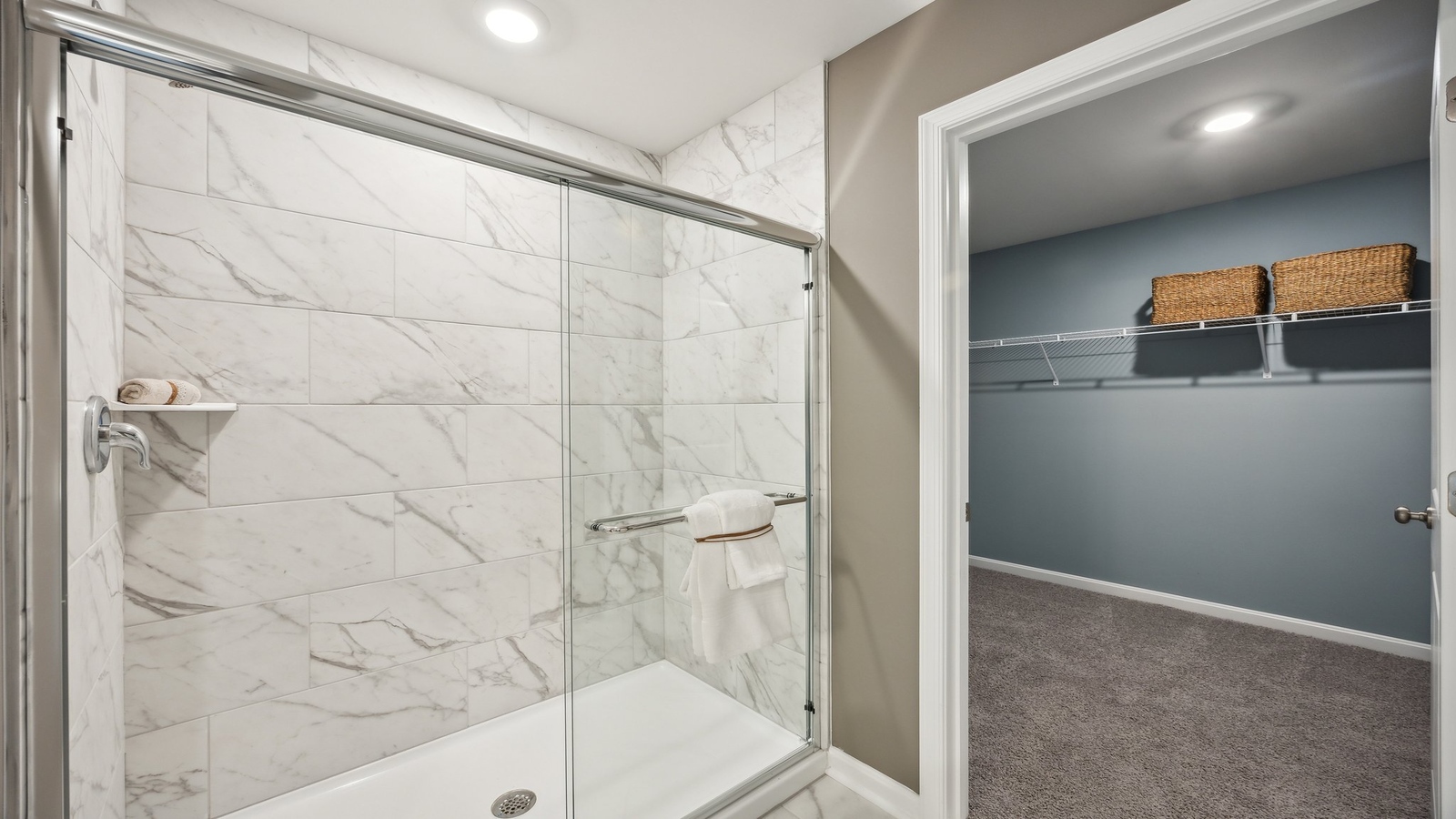 Primary ensuite bathroom in this D.R. Horton new home featuring expansive vanity with dual sinks, shower, tub, walk-in closet