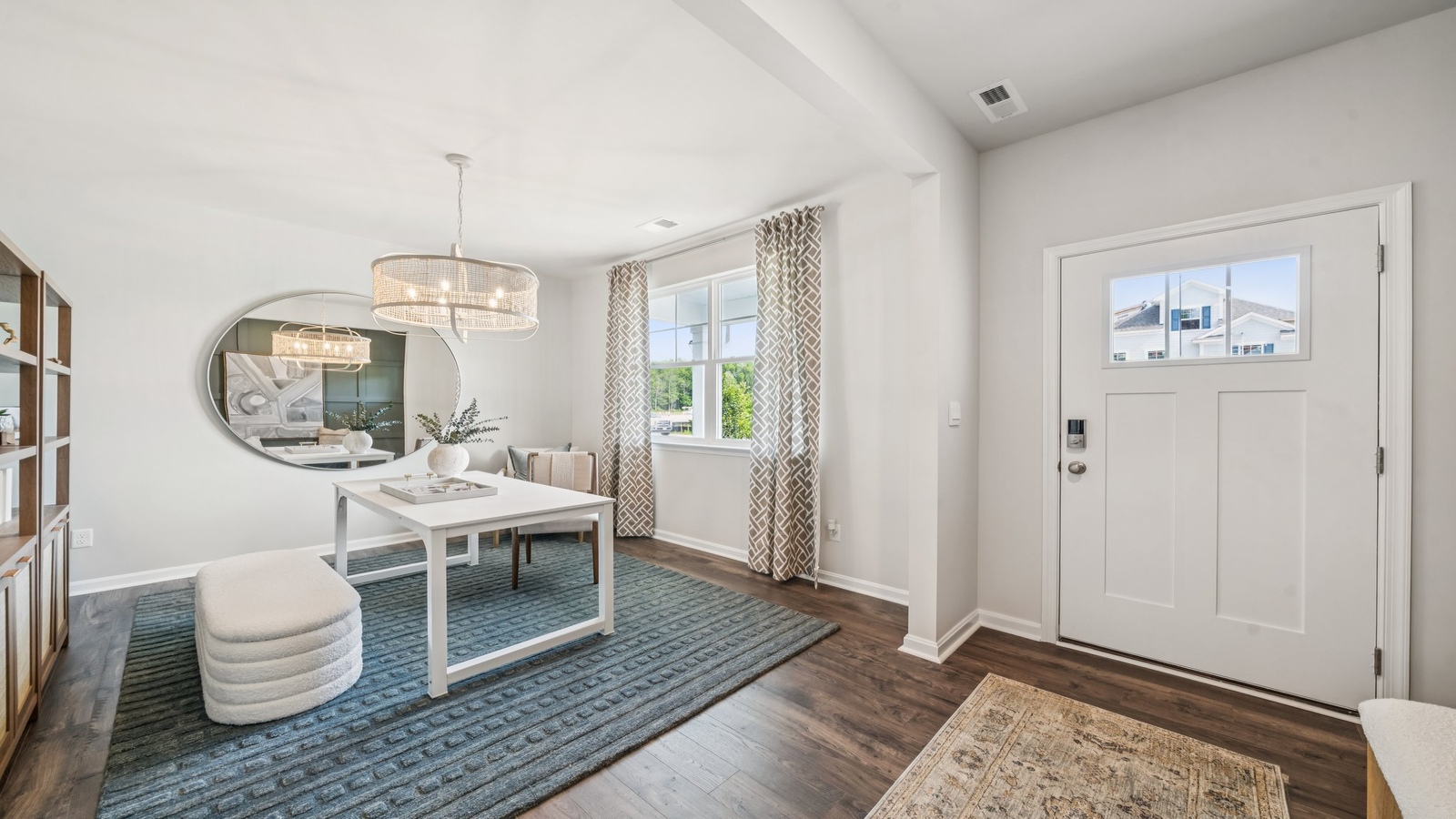 New home front hallway by D.R. Horton showcases the open design entry, stairs, garage, and central living zones access